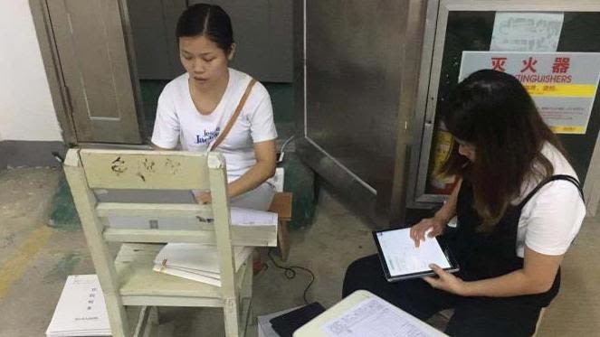 2 women retrieving medical records of hospitalised participants using the portable verification device (PVD) system